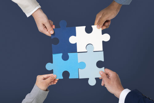 Hands holding puzzle piece symbolizing business problem solving with reliable technology solutions for businesses.
